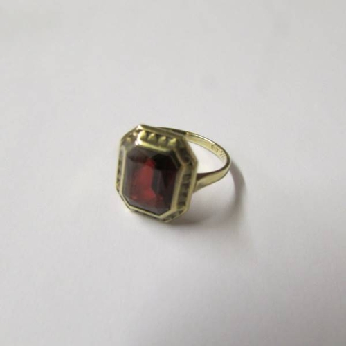 137 - An art deco gold ring set large red stone.