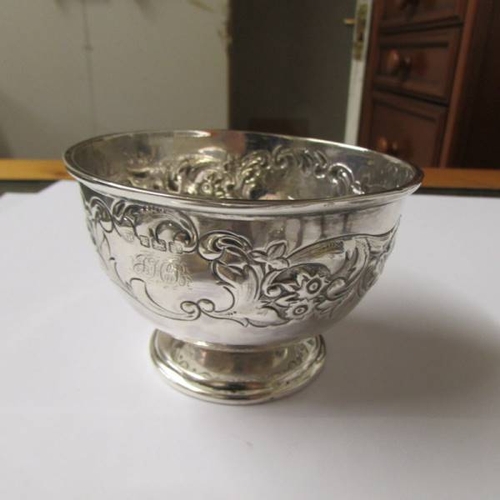 140 - A small embossed silver bowl (67 grams), a silver plate comport, a pair of silver plate berry spoons... 