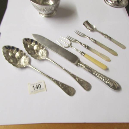 140 - A small embossed silver bowl (67 grams), a silver plate comport, a pair of silver plate berry spoons... 