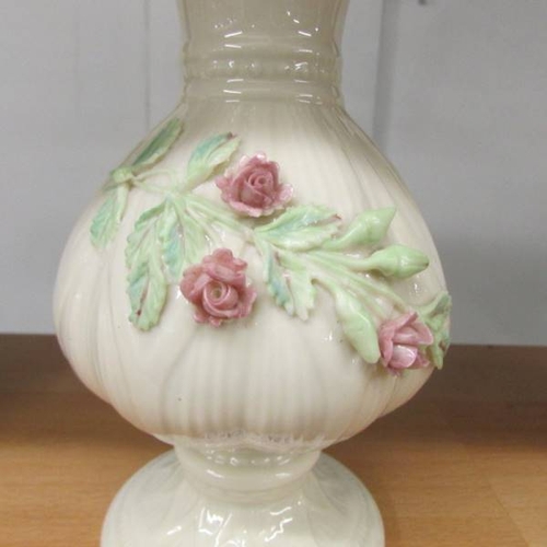 142 - A belleek vase with applied rose decoration, 20 cm tall.