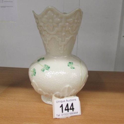 144 - A Belleek vase decorated with shamrocks. 15 cm tall.