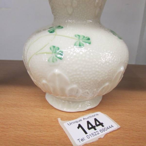 144 - A Belleek vase decorated with shamrocks. 15 cm tall.