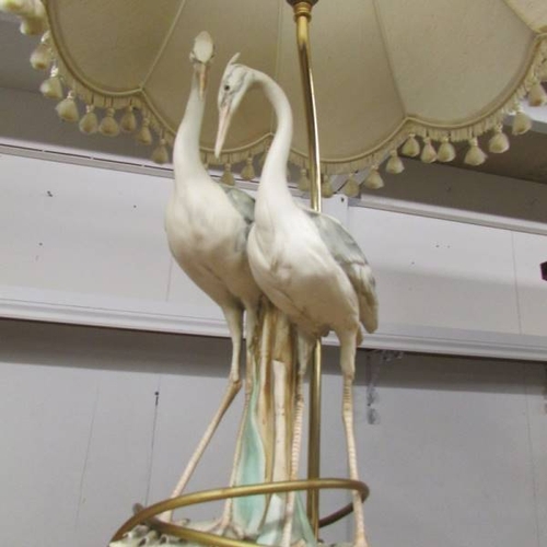 149 - A table lamp in the form of a pair of storks complete with shade,  Tail on one bird a/f.