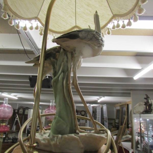 149 - A table lamp in the form of a pair of storks complete with shade,  Tail on one bird a/f.