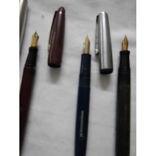 297 - A good collection of fountain pens (4 with gold nibs) and a quantity of ball point pens.