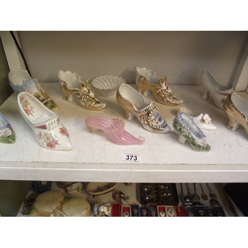 373 - 2 shelves of collectors shoes, spoons, 2 items of Pendelfin etc.