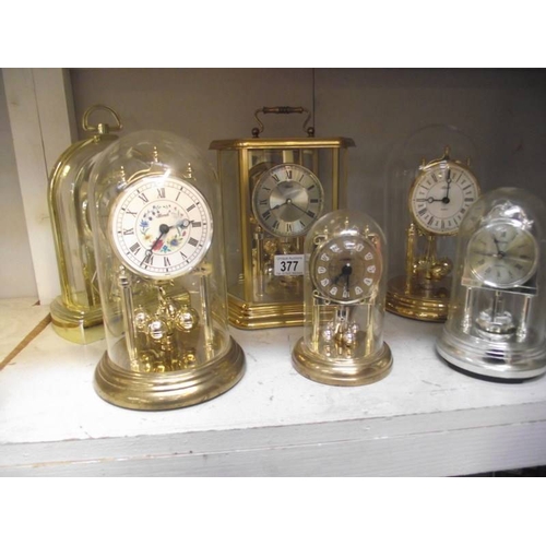 377 - 6 clocks including anniversary clocks under plastic domes