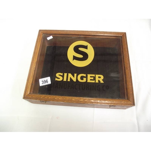 396 - A table top display cabinet with Singer advertising