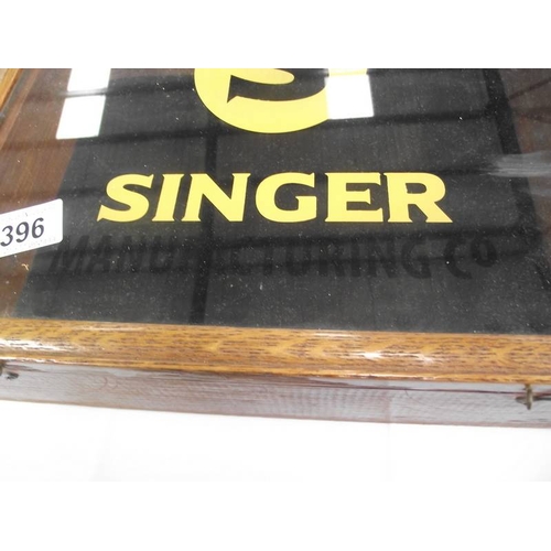 396 - A table top display cabinet with Singer advertising