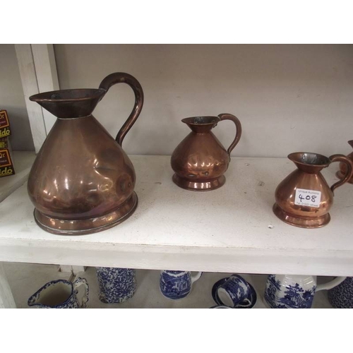 408 - A set of seven graduated copper ale jugs