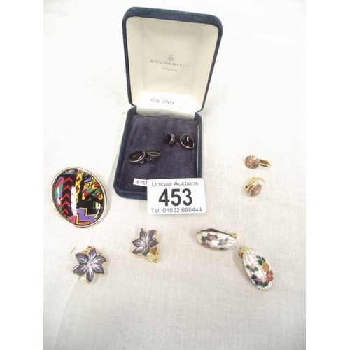 453 - A pair of silver and onyx cufflinks, an enamel brooch and 3 pairs of enamel earrings