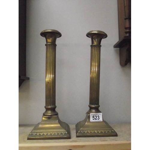 523 - A pair of brass reeded column candle sticks