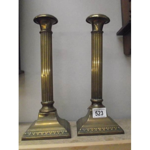 523 - A pair of brass reeded column candle sticks