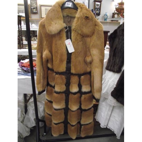 566 - A 1970's leather/fur unusual design coat, rich golden fur set into dark leather, approximate length ... 