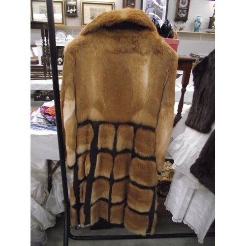 566 - A 1970's leather/fur unusual design coat, rich golden fur set into dark leather, approximate length ... 