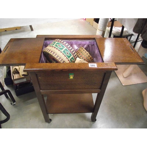 580 - A 1930's oak sewing box with contents.