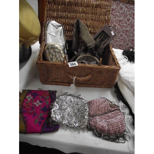 584 - A wicker basket containing vintage evening bags etc.,