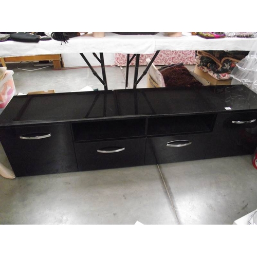 586 - A long low black sideboard with drawers and cupboards.