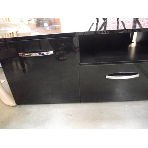 586 - A long low black sideboard with drawers and cupboards.