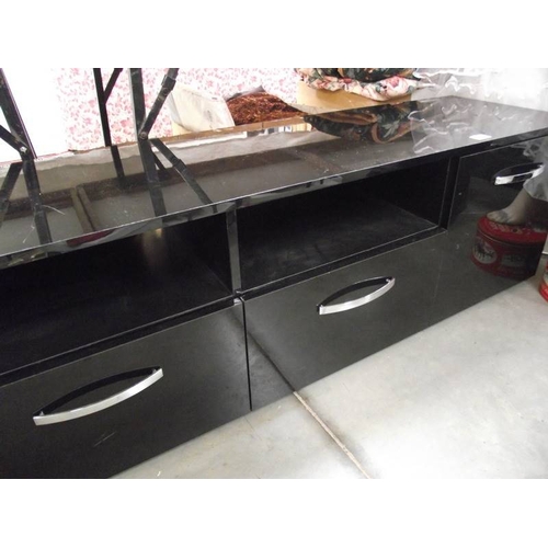 586 - A long low black sideboard with drawers and cupboards.