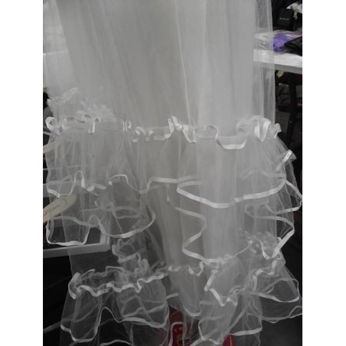 587 - A fairytale wedding dress with heavy frilled net on a satin underskirt with a train, approximate siz... 