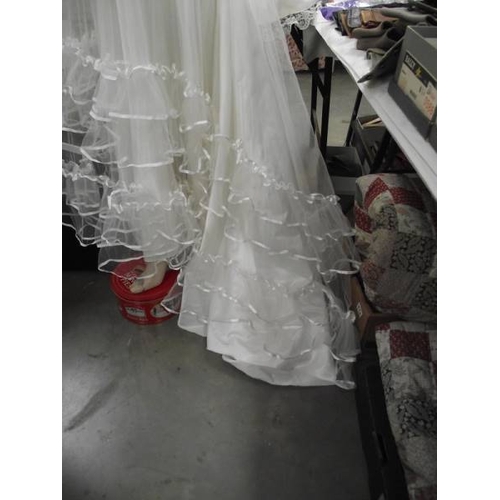 587 - A fairytale wedding dress with heavy frilled net on a satin underskirt with a train, approximate siz... 