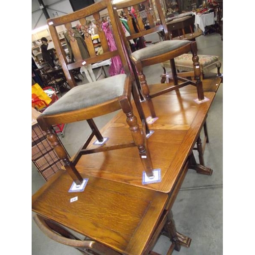 616 - A 1950's oak draw leaf table with 4 chairs.