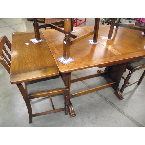 616 - A 1950's oak draw leaf table with 4 chairs.