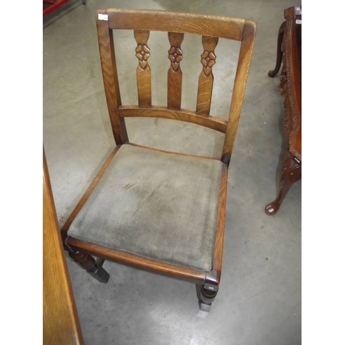 616 - A 1950's oak draw leaf table with 4 chairs.