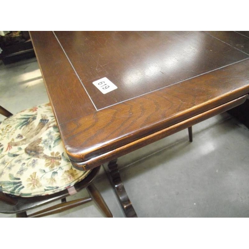 619 - A dark oak draw leaf table and 4 Ercol chairs.