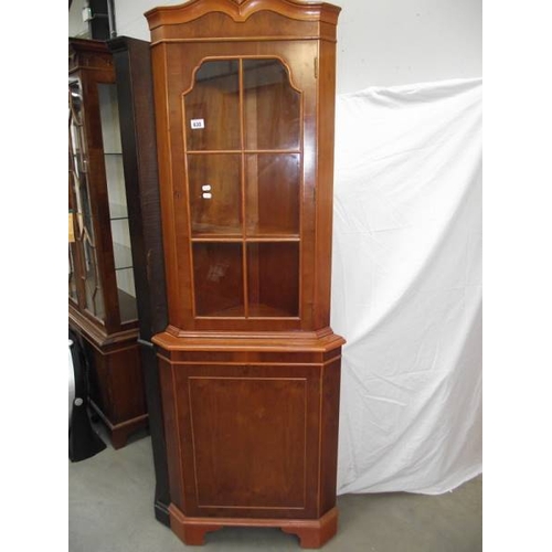 630 - A light wood (yew) corner cabinet.