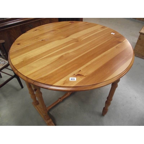 633 - A solid pine gate leg kitchen table.