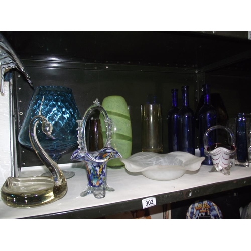 302 - A selection of coloured glass ware including vases and bowls and 3 glass blue bottles