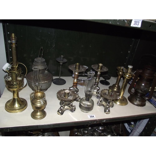 304 - A selection of metal candlesticks, oil lamps etc.