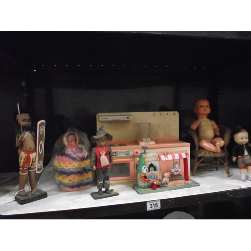 316 - A selection of old dolls including kitchen unit, wicker chair tinplate clockwork toy etc.