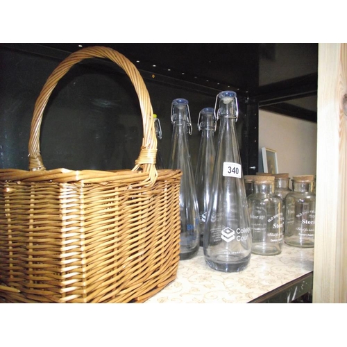 340 - A wicker bottle basket, 6 cod bottles, quantity of storage jars etc.