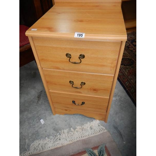 195 - A pine effect 3 drawer bedside chest.