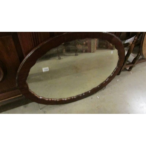 1594 - An oval framed mirror.