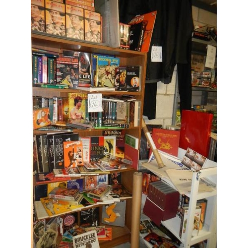 14 - Nine shelves of Bruce Lee related items, Kung Fu books. posters, videos etc.,