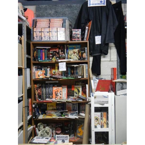 14 - Nine shelves of Bruce Lee related items, Kung Fu books. posters, videos etc.,