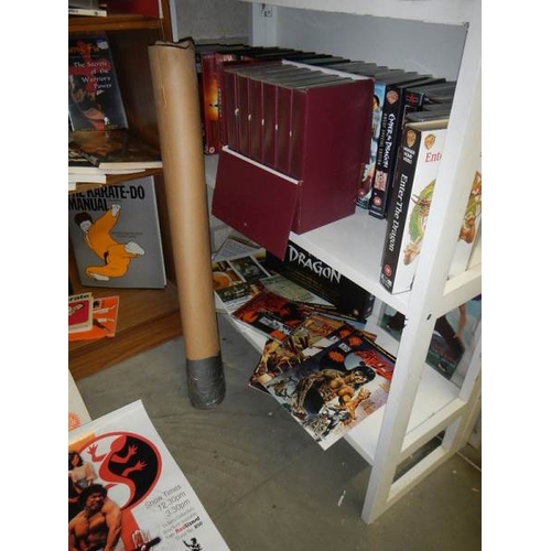 14 - Nine shelves of Bruce Lee related items, Kung Fu books. posters, videos etc.,