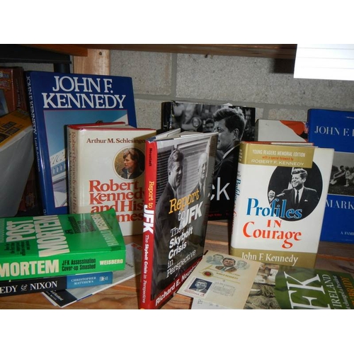 26 - Three shelves of JFK hardback books. paperback books and other memorabilia etc.,