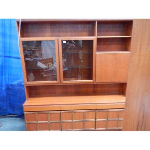 545 - A large teak wall unit with 3 doors to base, 3 drawers and glass fronted cupboards, lit.  180 x 115 ... 