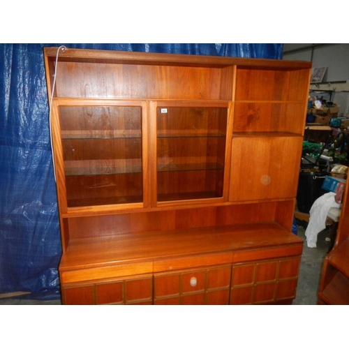 545 - A large teak wall unit with 3 doors to base, 3 drawers and glass fronted cupboards, lit.  180 x 115 ... 