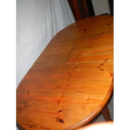 565 - An oval teak extending table, 127 cm (open), 110 cm (closed) x 80 x 74 cm.