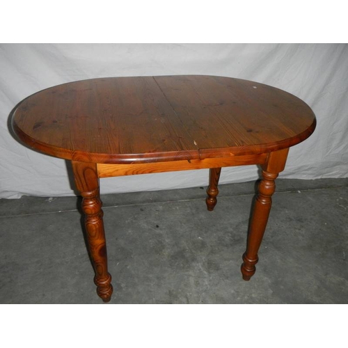 565 - An oval teak extending table, 127 cm (open), 110 cm (closed) x 80 x 74 cm.