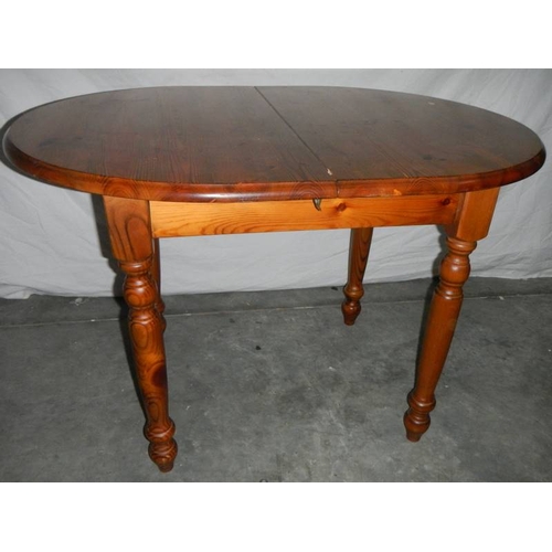 565 - An oval teak extending table, 127 cm (open), 110 cm (closed) x 80 x 74 cm.