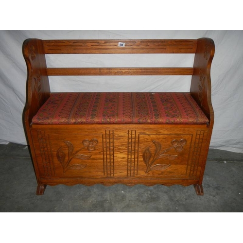 568 - A pine cushioned settee with carved flowers, 45 x 100 x 83 cm,