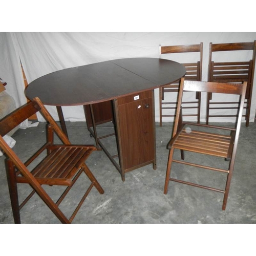 581 - A good fold out oak veneer table with 4 folding chairs inside, 135 x 97 x 74 when open.