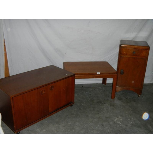 596 - A sliding door cabinet on wheels, a 1930's bedside cabinet and a G plan table.